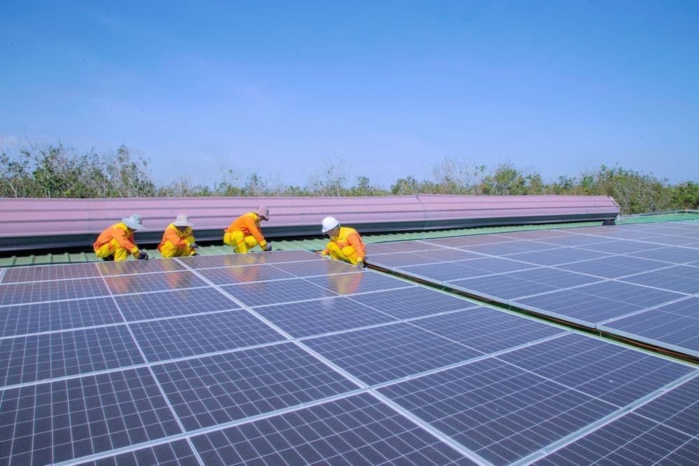 Technicians installing solar panels on a rooftop